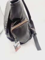 A black leather backpack with silver stud accents and multiple zippered compartments. The main flap is partially open, and there is a tag attached to the bag featuring an image of a horse. The straps are visible on the right side of the backpack.