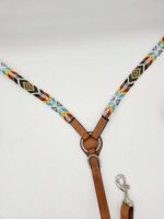 A beaded dog leash with a vibrant geometric design featuring black, white, red, yellow, and blue beads. The leash also has brown leather elements and a metal clasp at the bottom for attaching to a collar or harness. It is laid out against a white background.