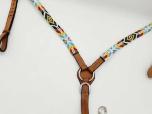 A leather horse breast collar with intricate, colorful beadwork featuring geometric patterns. The collar has metal rings and buckles for attachment, along with a metal snap hook for securing to other tack. The background is plain and white.