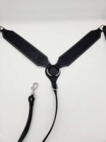 A black and silver dog harness with intricate floral patterns embroidered on the straps. The harness is laid flat on a white background, with the leash attached to a central ring via a clip.