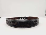 A black leather belt with intricate sunflower engravings is displayed on a white background. The belt features silver studs and buckle, adding to its decorative design.