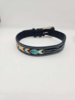 A black leather bracelet with a colorful, intricate beadwork pattern featuring zigzag and triangular designs. The bracelet has a metal buckle closure and lies on a plain white background.