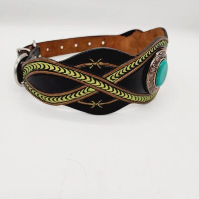 A black leather dog collar with intricate green leather designs and a turquoise stone centerpiece. The collar has a metal buckle and stitching details on the edges. The background is plain white.