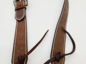 A brown leather belt with white stitching and a silver buckle is lying on a white background. The belt has leather strings tied around it and is slightly coiled at the top.