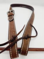 A close-up image of a brown leather belt with white stitching. The belt features a silver metal buckle and has two leather straps hanging loosely from it. The background is plain white, emphasizing the details of the belt.