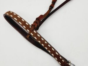 A brown leather belt with white stitching and metal buckle is laid out flat on a white surface. The belt has an intricate loop and knot design near the buckle, adding a decorative touch.