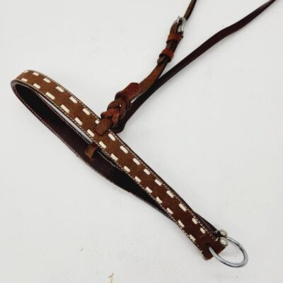 A brown leather belt with white stitching and metal buckle is laid out flat on a white surface. The belt has an intricate loop and knot design near the buckle, adding a decorative touch.