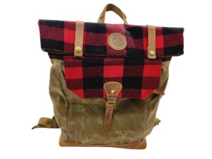 A stylish backpack featuring a red and black checkered top flap, secured with two brass buttons, and a buckle strap closure. The body of the backpack is made of olive green canvas with brown leather accents and adjustable straps.